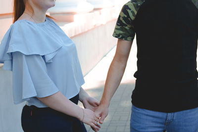 Rear view of couple holding hands