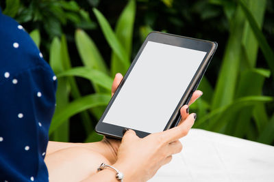 Cropped image woman using digital tablet