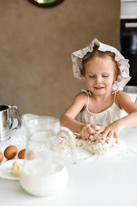 Little girl cooking pizza in the kitchen