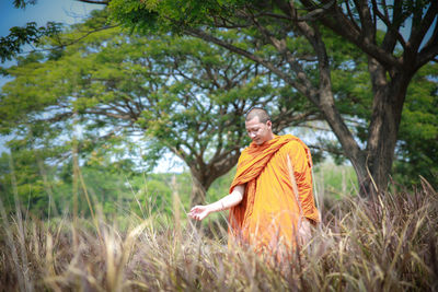 Low angle view of woman standing on tree