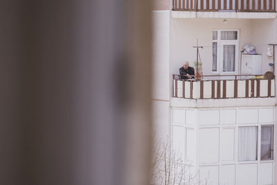 People standing by window of building