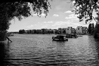 River amidst buildings in city against sky