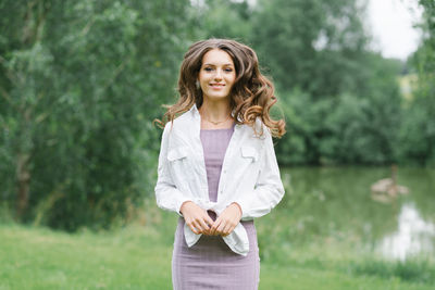 A happy woman in nature. portrait of a beautiful girl in close-up on the background of the lake. 