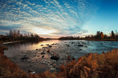 Scenic view of lake against sky at sunset