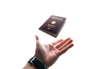 Close-up of hand holding text against white background