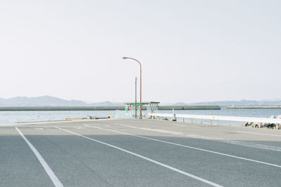 Street by sea against clear sky