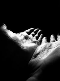 Close-up of hand over black background