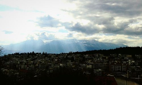 View of cityscape against cloudy sky