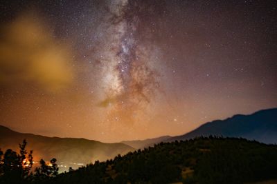 Scenic view of mountains against sky at night with milky way 