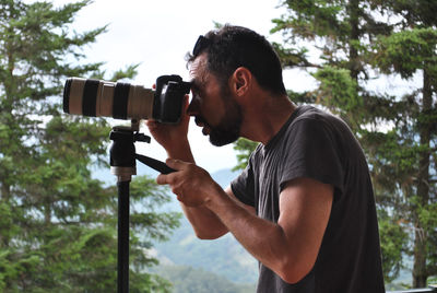 Side view of man photographing camera