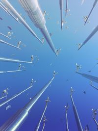 Directly below shot of windmills against clear blue sky