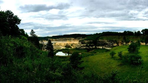 Scenic view of grassy field against cloudy sky