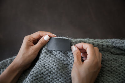 Cropped hands of woman holding sweater