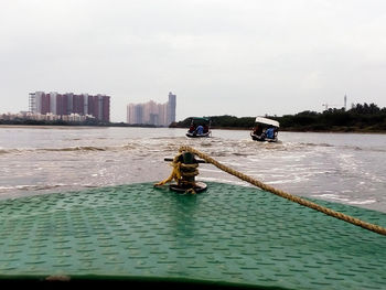 Boats in river with buildings in background