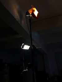 Low angle view of man photographing illuminated lamp