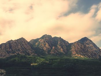 Scenic view of mountains against cloudy sky