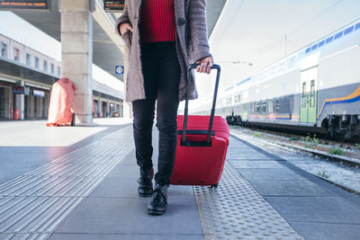 Close up of a woman walking and dragging luggage suitcase bag