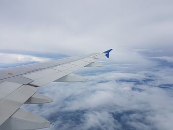 Aircraft wing against cloudy sky