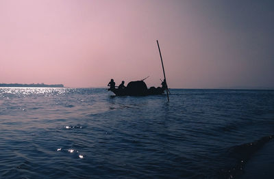 People in sea against sky