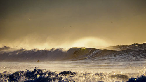 Idyllic view of splashing sea waves against sky