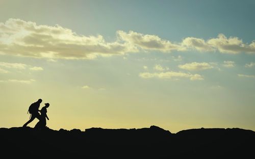 Silhouette man standing against sky at sunset