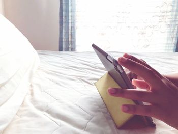 Midsection of woman hand on bed at home