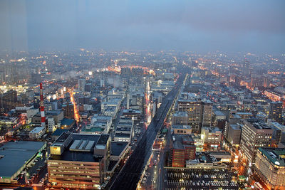 High angle view of illuminated city buildings against sky