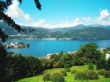 View of island amidst lake with mountains in foreground