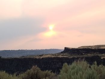 Scenic view of land against sky during sunset