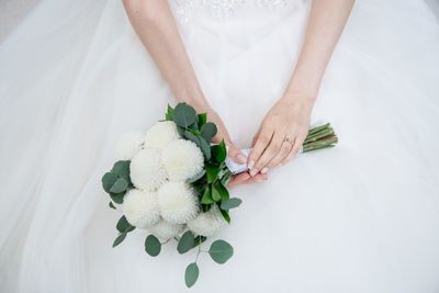 High angle midsection of bride with bouquet
