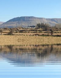 Scenic view of lake and mountains against clear sky