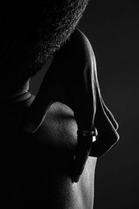 Rear view of shirtless man against black background