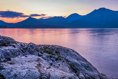 Scenic view of lake and mountains against sky during sunset