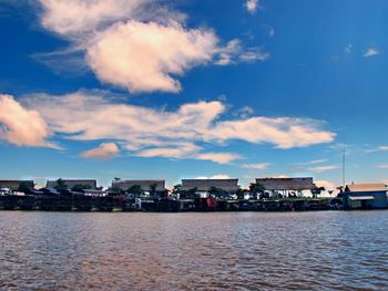 Sea by buildings against sky in city