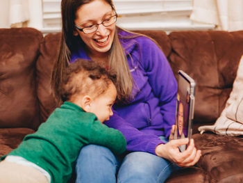 Smiling mother and son talking on video call at home