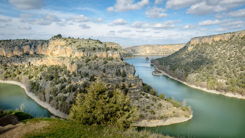 Scenic view of river amidst mountains against sky