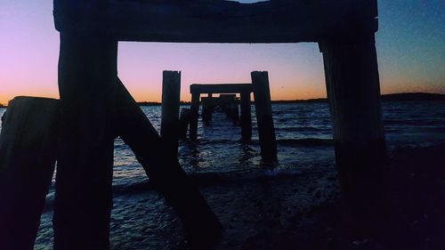Silhouette men on beach against sky during sunset