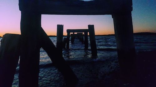 Silhouette men on beach against sky during sunset