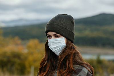 Portrait of young woman wearing hat outdoors