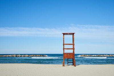 Lifeguard hut on beach against sky