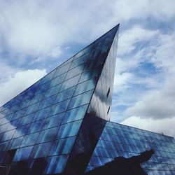 Low angle view of modern building against cloudy sky