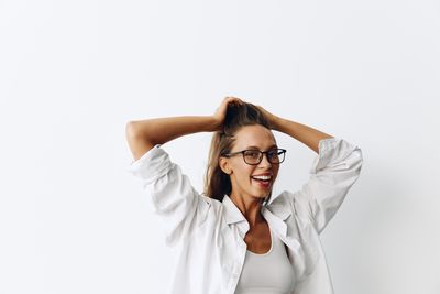 Young woman with arms crossed against white background