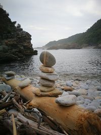 Stack of stones on beach against sky