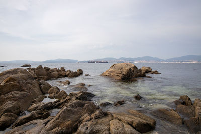 Rocks on beach against sky