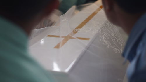 Rear view of people working on table