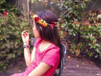 Side view of woman with pink flower