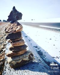 Stack of pebbles on beach against sky