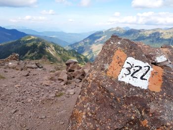 Text on rock against sky