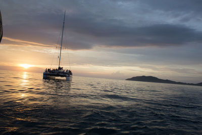 Boats in sea at sunset