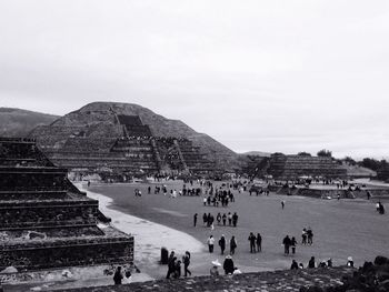 Tourists on mountain against sky